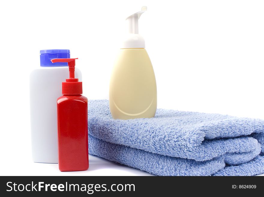 Body care products and towel on white background