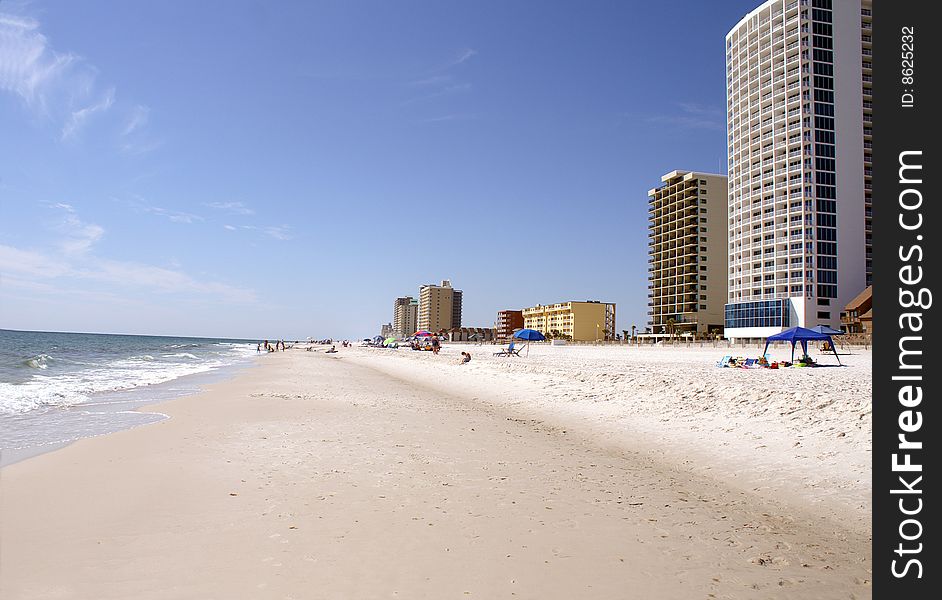 People and condos along the Gulf Coast beach on a bright sunny day. People and condos along the Gulf Coast beach on a bright sunny day.