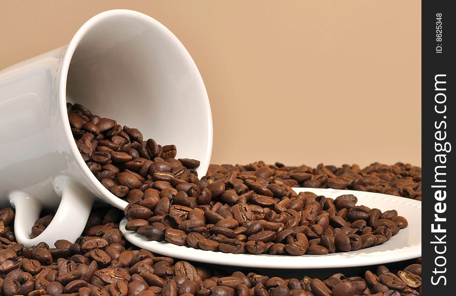Coffee beans spilling out of a mug. Coffee beans spilling out of a mug