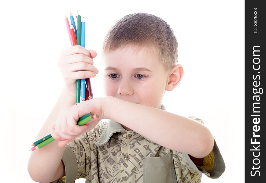 6 year old boy draws pencils sitting for a table. 6 year old boy draws pencils sitting for a table