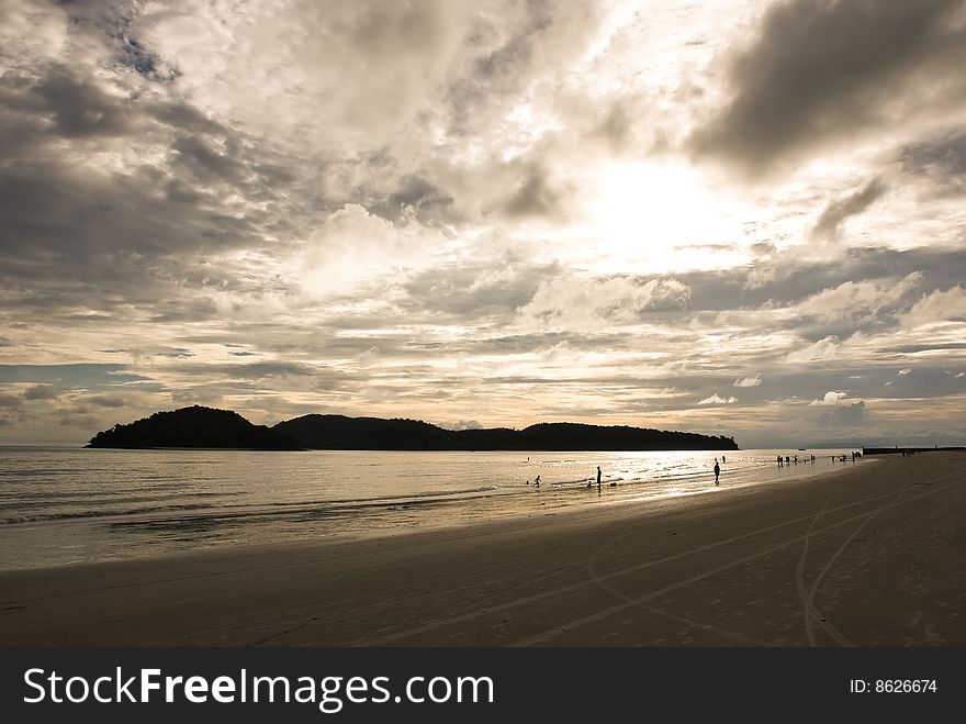 Sunset on a beach with people silhouettes. Sunset on a beach with people silhouettes