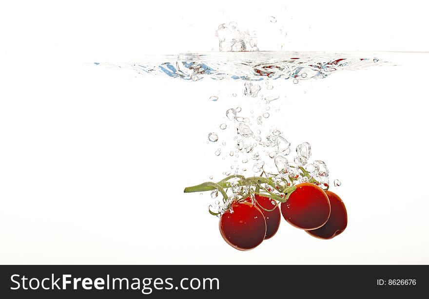 Tomatoes are falling into water. Tomatoes are falling into water