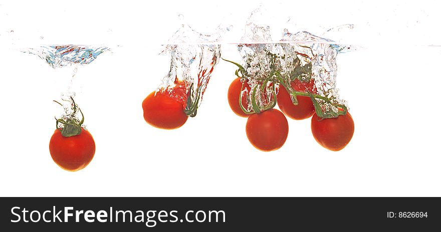 Tomatoes are falling into water. Tomatoes are falling into water