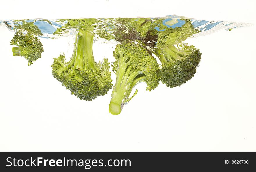 Broccoli is falling into water. Broccoli is falling into water