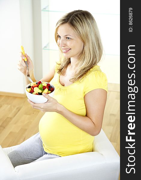 Pregnant woman is eating fruits