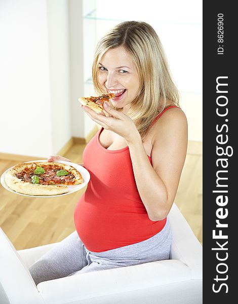 Young pregnant woman eating pizza