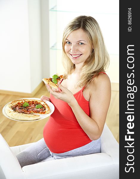 Young pregnant woman eating pizza