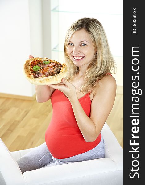 Young pregnant woman eating pizza