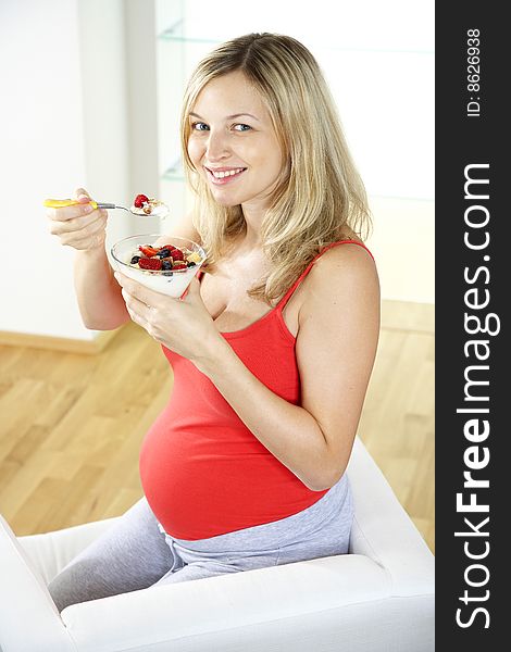 Young, beautiful pregnant woman is eating muesli. Young, beautiful pregnant woman is eating muesli