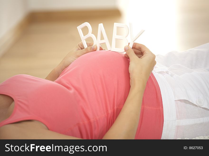Pregnant woman keeps baby stroke on her belly. Pregnant woman keeps baby stroke on her belly