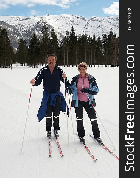A senior couple outdoor in a winter setting. The active couple is about to go crosscountry skiing. A senior couple outdoor in a winter setting. The active couple is about to go crosscountry skiing.