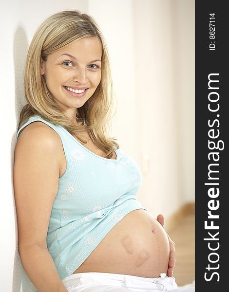 Pregnant woman with a big belly is laughing