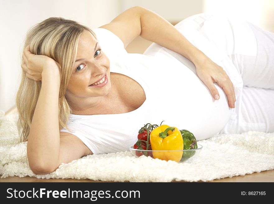 Young pretty pregnant woman with vegetables