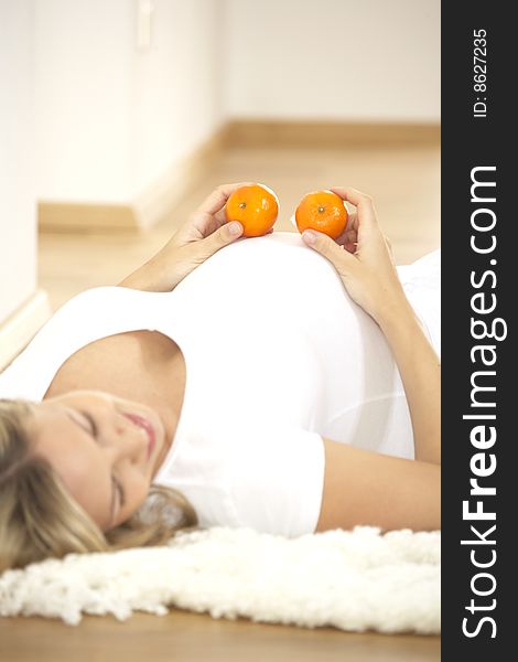 Young Pretty Pregnant Woman With Oranges
