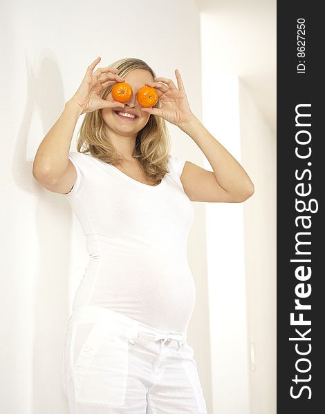 Young Pretty Pregnant Woman With Oranges