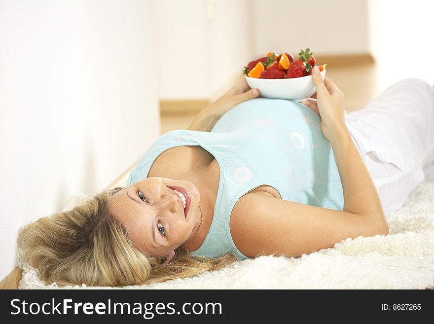 Young Pretty Pregnant Woman Eats Strawberries