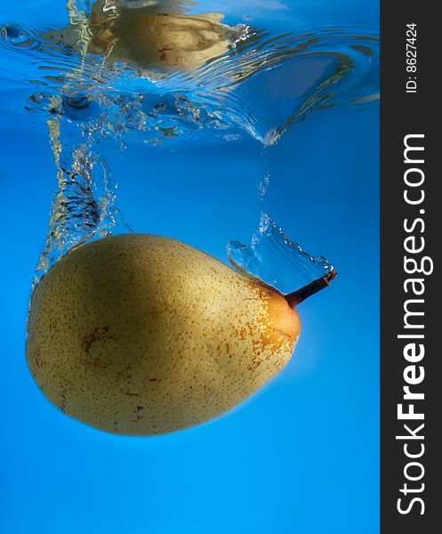 Pear in water on a blue background