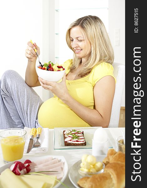 Pregnant woman eats fruit salad