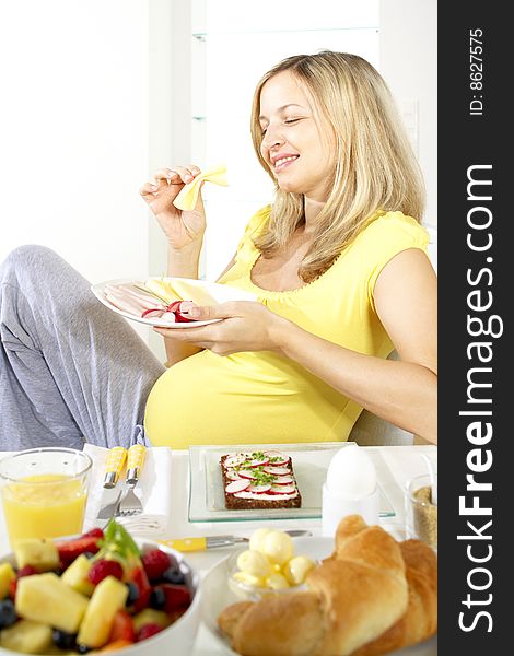Young beautiful pregnant woman having breakfast. Young beautiful pregnant woman having breakfast