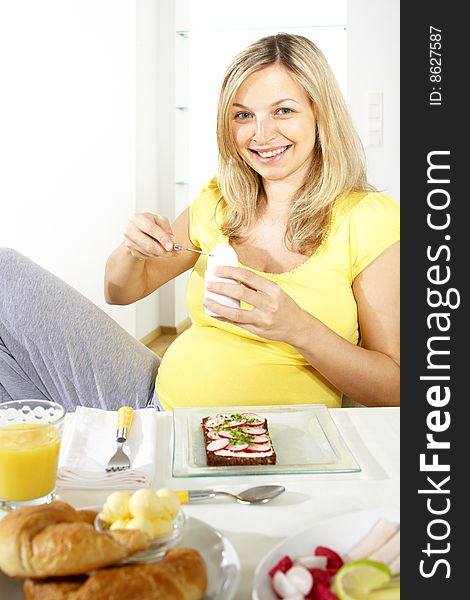 Young beautiful pregnant woman having breakfast. Young beautiful pregnant woman having breakfast