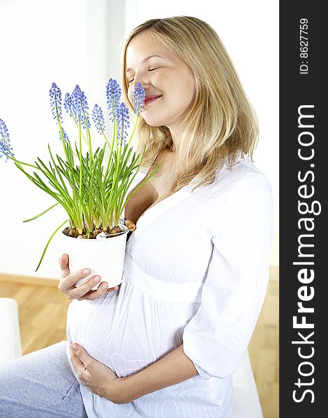 Young beautiful pregnant woman is holding hyacinths