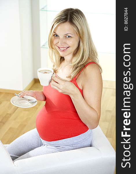 Pregnant woman is drinking coffee
