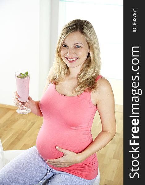Young pregnant woman with milkshake