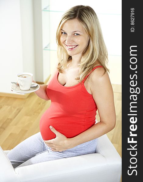 Pregnant woman is drinking coffee