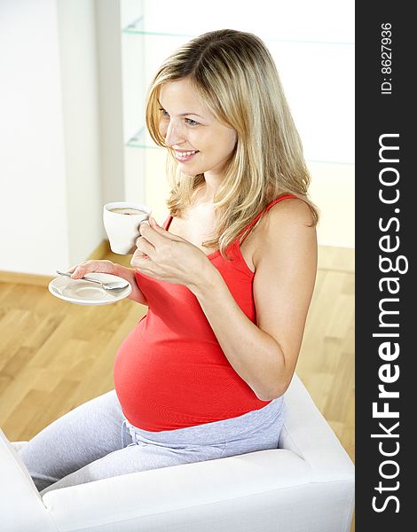 Pregnant woman is drinking coffee