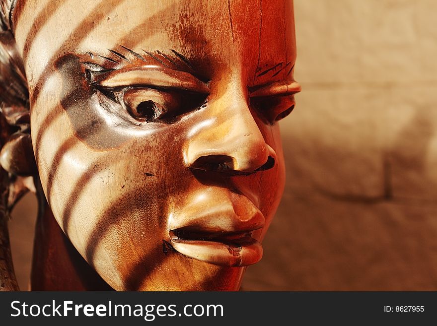 Ancient wooden sculpture from Africa on a sunlight.