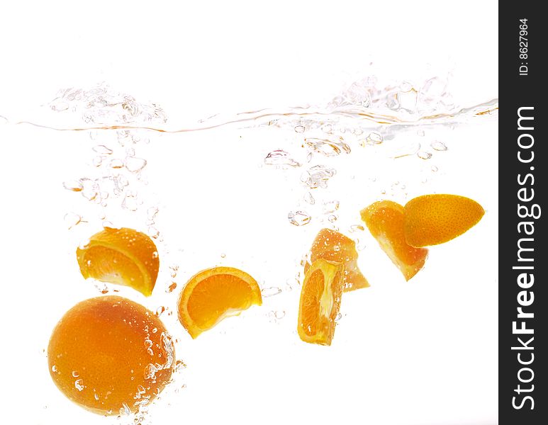 Mandarins are falling into clear water. Mandarins are falling into clear water