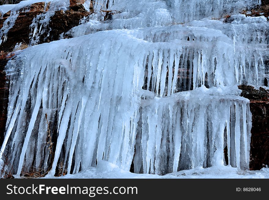Hanging icicles formed by the melting snow over the cliff