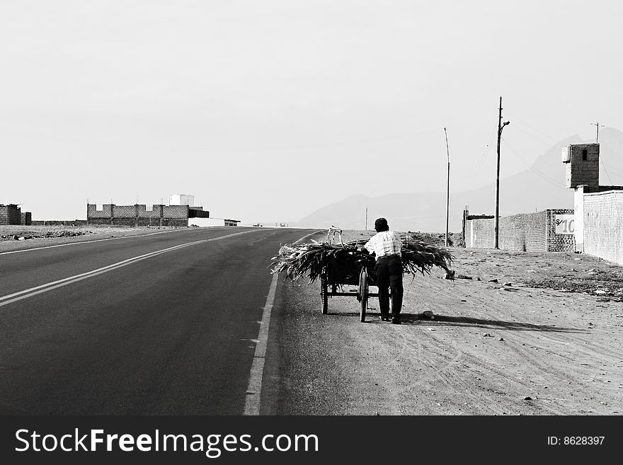 Pushing a cart of corn in Peru along an abandoned roadway. Pushing a cart of corn in Peru along an abandoned roadway
