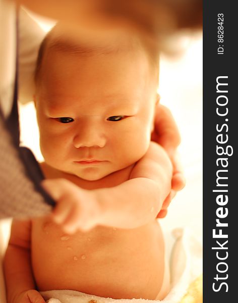 Cute baby boy holding mom's collar