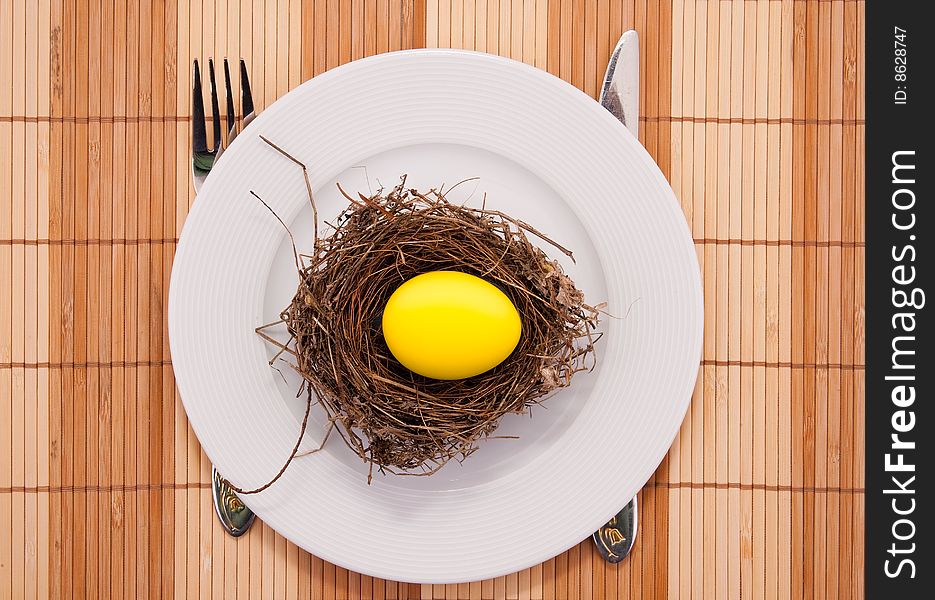 Chicken golden egg in a nest served on a plate