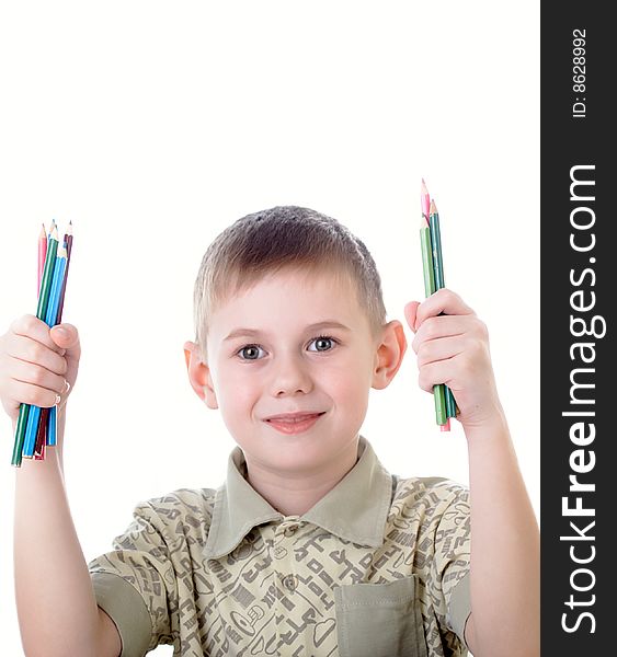 6 year old boy draws pencils sitting for a table. 6 year old boy draws pencils sitting for a table