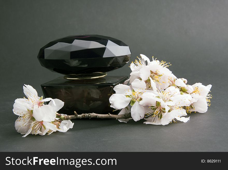 Perfume with flower on a black background