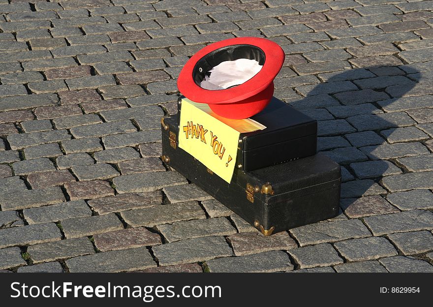 Asking for a contribution. Upturned hat on a musical instrument box with a sign saying Thank You. Asking for a contribution. Upturned hat on a musical instrument box with a sign saying Thank You