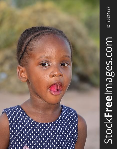 A close-up portrait of a young african girl looking at the camera with mouth wide open. A close-up portrait of a young african girl looking at the camera with mouth wide open