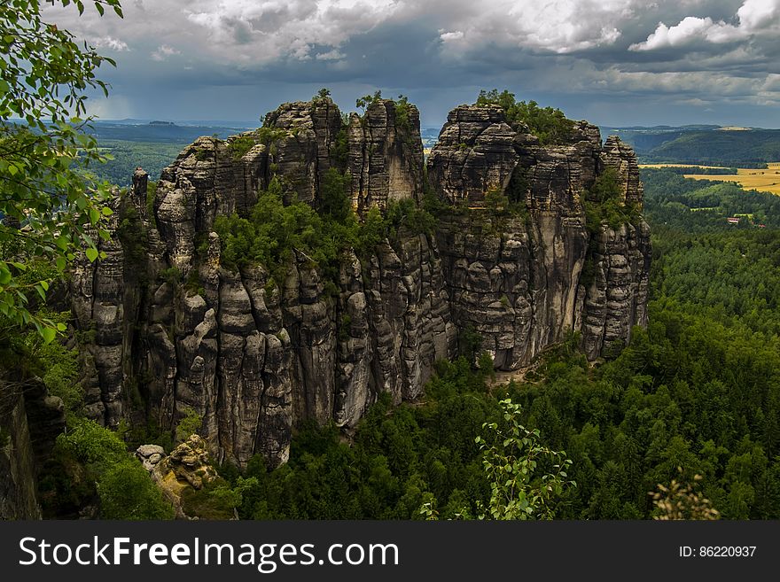 Rock Formation Surrounded by Green Trees during Humid Weather