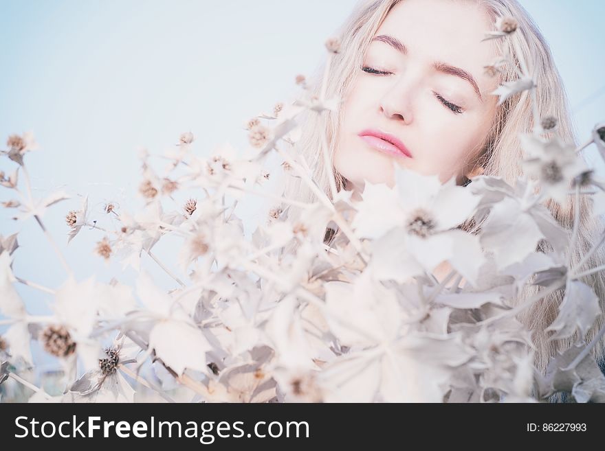 Blond woman surrounded by flowers