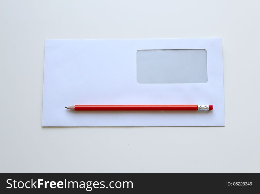Envelope with address window, sheet of blank paper and red pencil with rubber on the end. Envelope with address window, sheet of blank paper and red pencil with rubber on the end.