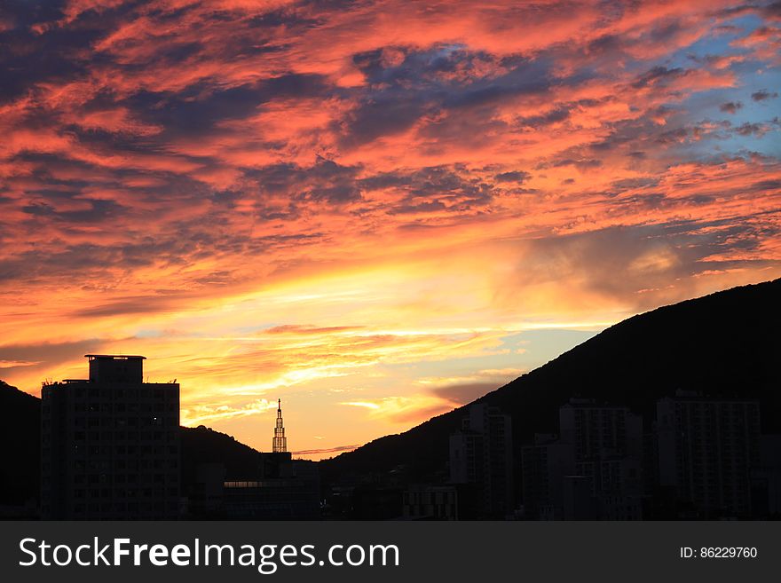 Silhouette Cityscape Against Dramatic Sky during Sunset