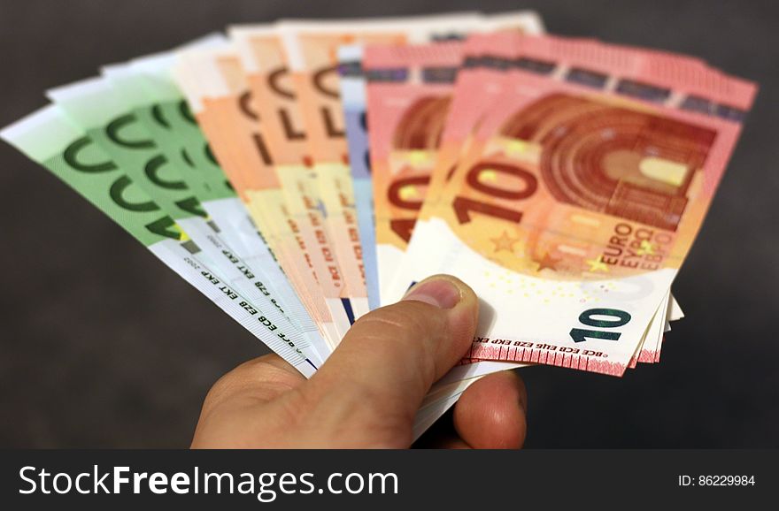 Hand holding fan of Euro notes in various denominations. Hand holding fan of Euro notes in various denominations.