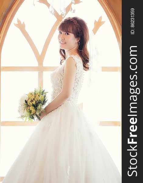 Portrait of bride in wedding gown holding bouquet smiling in church. Portrait of bride in wedding gown holding bouquet smiling in church.