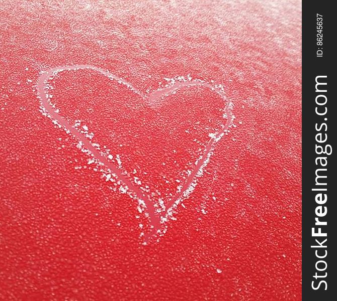 Heart etched in the frost on top of my red car. Heart etched in the frost on top of my red car