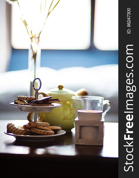 A coffee table set with cookies and tea pot. A coffee table set with cookies and tea pot.