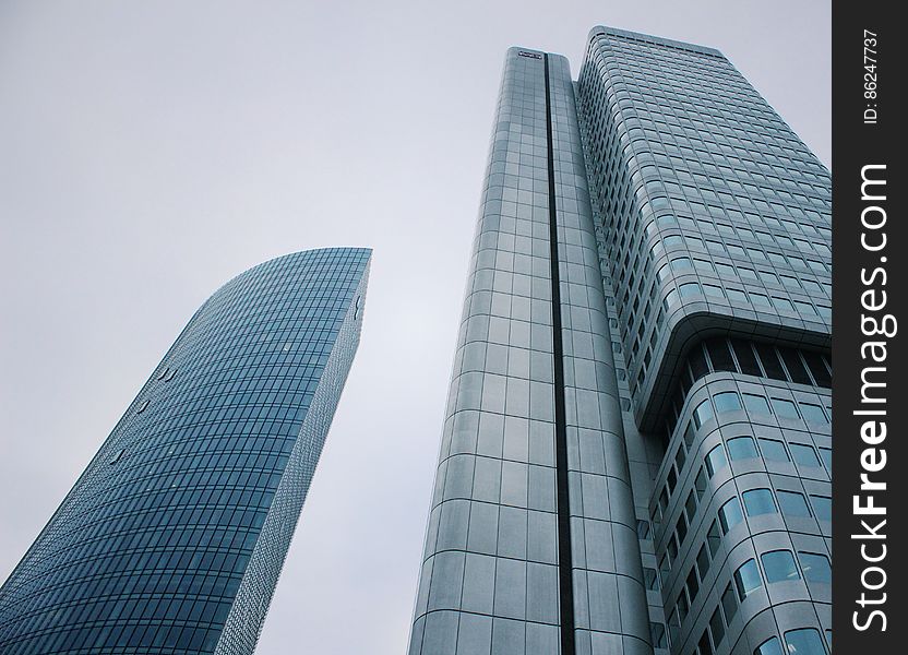 Steel, glass and concrete high rise buildings (skyscrapers) showing a number of novel features including a curved facade and exposed structural elements, gray sky. Steel, glass and concrete high rise buildings (skyscrapers) showing a number of novel features including a curved facade and exposed structural elements, gray sky.