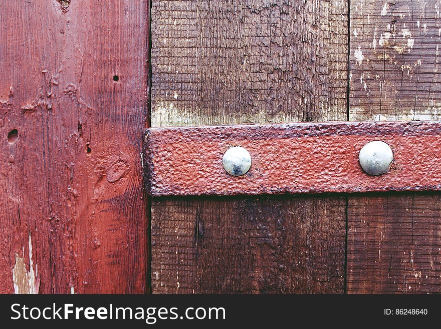 A close up of an old wooden door with a rusty steel detail.