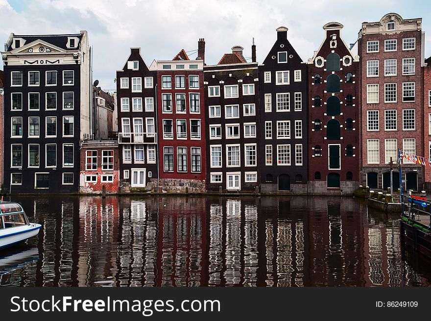 Tall historic buildings in European city reflecting on canal. Tall historic buildings in European city reflecting on canal.